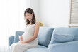 © polkadot - 笑顔でお腹を撫でる若い妊婦（妊娠・マタニティ）