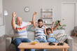 © Pixel-Shot - Man, his little son and father watching TV at home