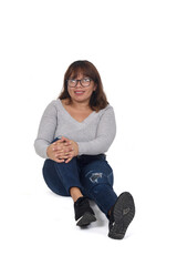 Wall Mural - front view of woman sitting on the floor, looking at camera and with the hand on the knee on white background