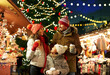 © Syda Productions - family, winter holidays and celebration concept - happy mother, father and little daughter with takeaway drinks at christmas market on town hall square in tallinn, estonia over lights