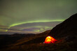 tent in the mountains and a spiral of green light