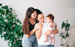 © Viktoria Ostroushko - A young happy female couple and their child are enjoying together at home. lesbian couple