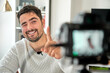 Smiling man pointing with finger up during video record