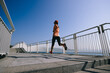 © lzf - Healthy lifestyle fitness sports woman runner running up stairs on seaside trail