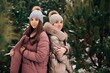 © Anhelina  - Two girls from the winter forest. Girls dressed in winter jackets and hats. Two sisters in a snowy forest. The cold weather. Snow-covered pines
