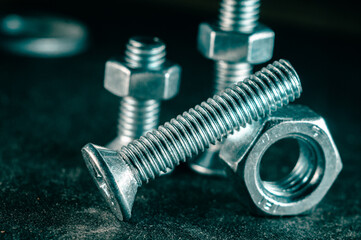 Wall Mural - Pile of bolts and nuts on a dark blurred background