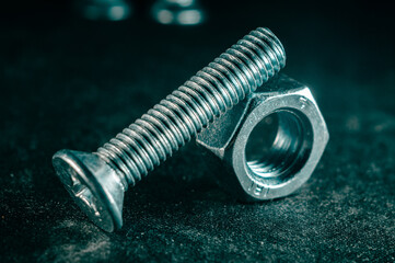 Poster - Pile of bolts and nuts on a dark blurred background