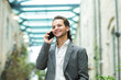 © Acronym - A young successful businessman is working outdoor using smartphone. Man in a casual wear. Business, freelance and remote work.