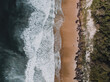 © Austockphoto - Drone shot of waves crashing on a beach from above