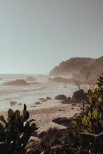 A Secluded, Rocky Beach On A Hazy Morning After Sunrise.