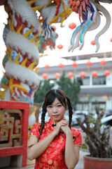 Wall Mural - beauty woman wear red cheongsam looking and smile in chinese new year