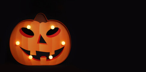 Wall Mural - Spooky Halloween pumpkin Jack O Lantern with glowing lamps on a black background. ?opy space for text.