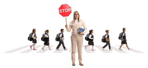 Poster - Female teacher holding a stop sign and schoolchildren crossing a street on a crosswalk