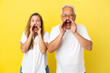 © luismolinero - Middle age couple isolated on yellow background shouting with mouth wide open