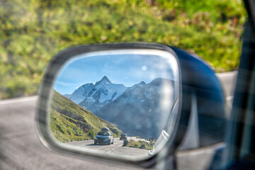 Road to a mountain peak, view from the car side mirror.