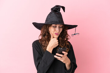 Young caucasian woman celebrating halloween isolated on pink background thinking and sending a message