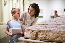 Young Woman With Son Observing With Interest Sculptures Exhibition In Art Museum