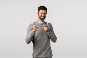 You rock man. Attractive and cheeky, confident bearded man, pointign finger pistols camera and wink as congratulating friend made good deal, praise amazing work, smiling satisfied, white background