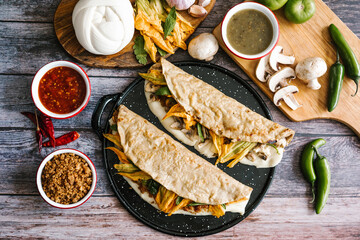 Mexican quesadilla made with tortilla and stuffed with pork rinds or mushrooms, squash blossom, oaxaca cheese, chili slices or salsa in Puebla City, Mexico