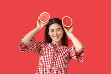 Poster - Funny young Asian woman with grapefruit on color background