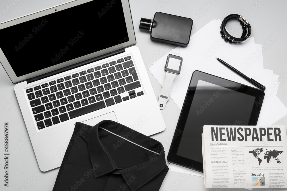 Stylish male accessories and modern gadgets on light background