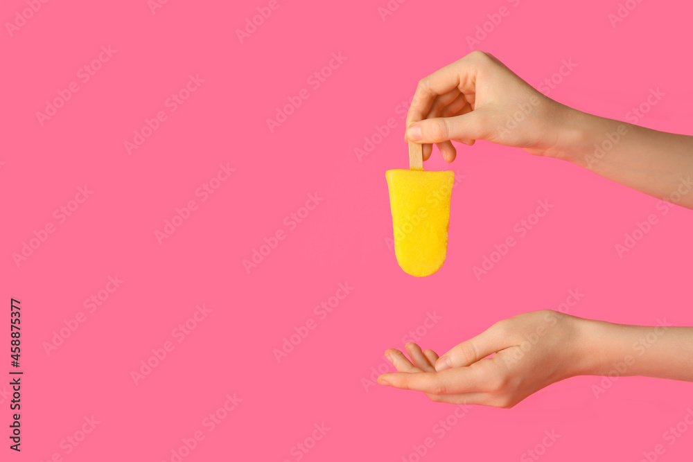 Female hands with tasty pineapple popsicle on color background
