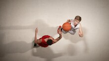 Top View Of Throw-in Of The Ball Before The Start Of The Game In Basketball Competition. Two Opposing Players Jumping For Possession Of The Ball. Slow Motion.