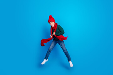 Full length body size photo boy jumping up wearing winter clothes isolated bright blue color background