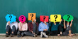 © Bangkok Click Studio - group of people holding speech bubble card with question mark sign in front of their faces. Sitting isolated in front of green background