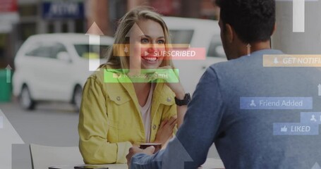 Canvas Print - Animation of social media icons floating over happy caucasian couple talking and drinking coffee