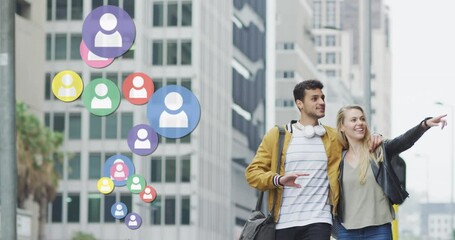 Wall Mural - Animation of social media icons floating over happy caucasian couple walking and smiling