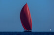 Sailing yacht with red gennaker in the sea