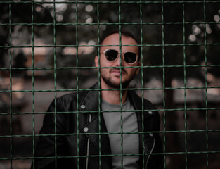 Iron fence in a cage on the background of a guy