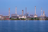 Fototapeta Nowy Jork - Twilight scene of oil refinery plant of Petrochemistry  front water reflection.