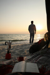 Sticker - Man enjoying sunset on seashore. Beach camping