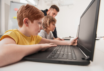 Wall Mural - smart boy working on laptop in classroom