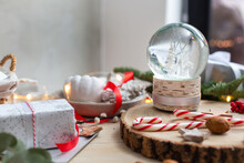 Christmas Decorations, A Snow Globe And Presents And Star Shaped Biscuits.