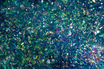 Blue and green glitter sparkle on a dark background. Vibrant background with twinkle lights. Modern texture