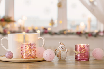 two white cups with christmas decorations on background window