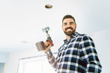 Wall Mural - Portrait of an electrician happy worker at work install light