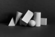 Platonic solids figures geometry. Abstract geometrical objects still life composition. Three-dimensional rectangular prism, cylinder pyramid cube, sphere on black gray background