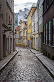 Fototapeta Uliczki - Narrow alley in medieval town with reflections on the ground from the rain.