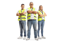Full Length Portrait Of Two Men And A Woman Wearing A Reflective Safety Vests And Posing With Crossed Arms