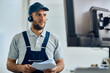 © Drazen - Smiling mechanic uses computer while communicating with customer via headset.