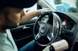© Drazen - Close-up of mechanic wraps steering wheel with cellophane at auto repair shop.