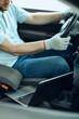 © Drazen - Close-up of mechanic runs diagnostic on laptop while sitting inside of car at workshop.