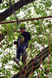 © Serhii - A teenage guy climbs a hanging ladder in a rope amusement park