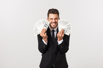 Wall Mural - Portrait of a satisfied young businessman holding bunch of money banknotes isolated over white background.