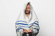 A religious Jew wrapped in a Tallit, prayer shawl with the inscription 