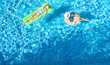 © Iuliia Sokolovska - Children in swimming pool aerial drone view from above, happy kids swim on inflatable ring donut and mattress, active girls have fun in water on family vacation on holiday resort